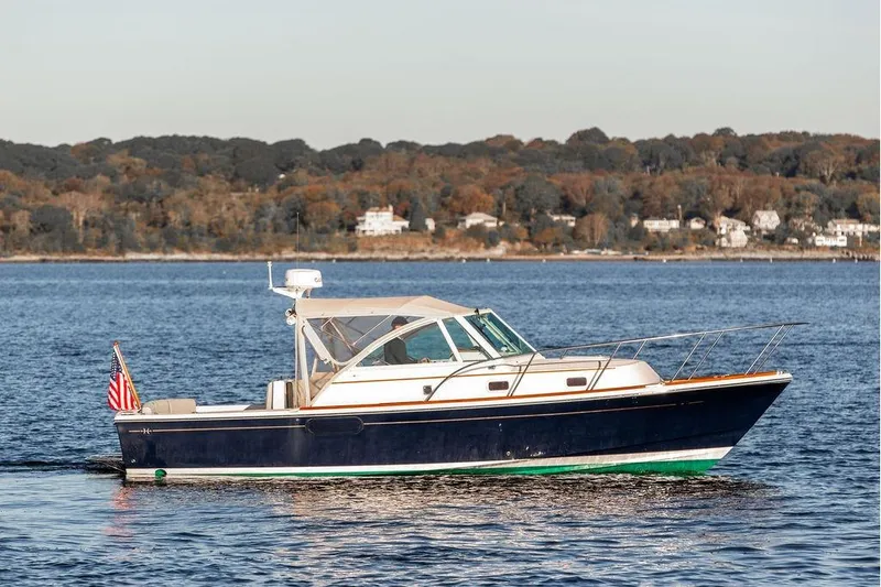 Slide: The Image of 2007 Hunt Surfhunter 29 boat cruising on a calm lake with scenic shoreline. - 10