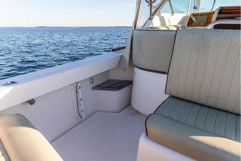 Slide: The Image of 2007 Hunt Surfhunter 29 boat interior with cushioned seating, overlooking calm ocean waters. - 22