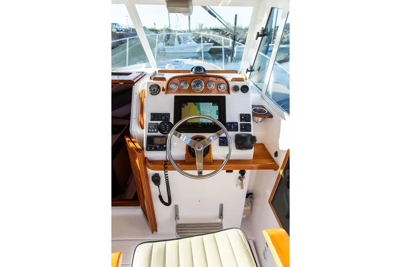 Slide: The Image of Helm of 2007 Hunt Surfhunter 29 with navigation instruments and wooden accents. - 26