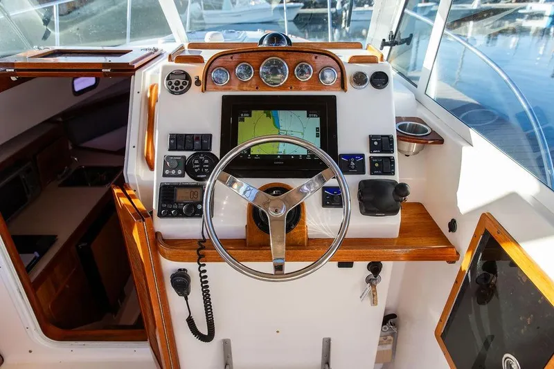 Slide: The Image of 2007 Hunt Surfhunter 29 boat cockpit with steering wheel and navigation equipment. - 27