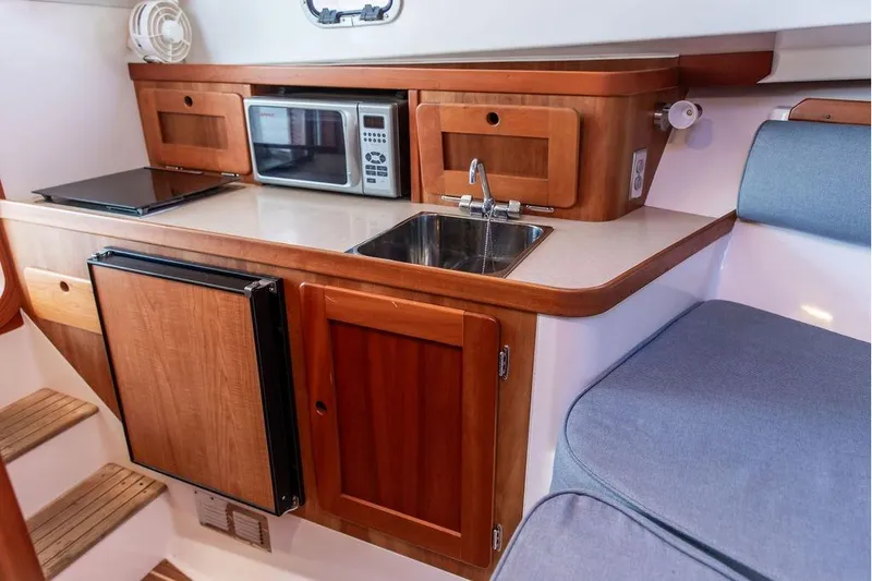 Slide: The Image of Compact kitchen area in a 2007 Hunt Surfhunter 29 boat with wooden cabinetry. - 34