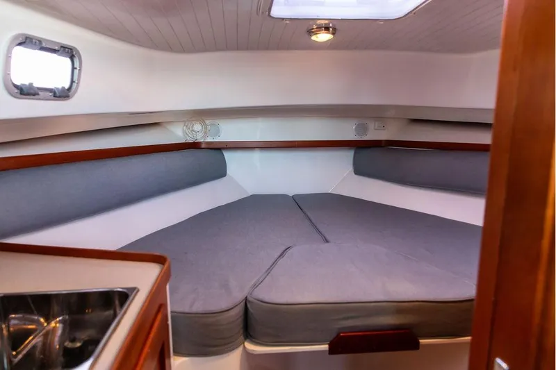 Slide: The Image of 2007 Hunt Surfhunter 29 cabin interior with cozy V-berth and wooden accents. - 39