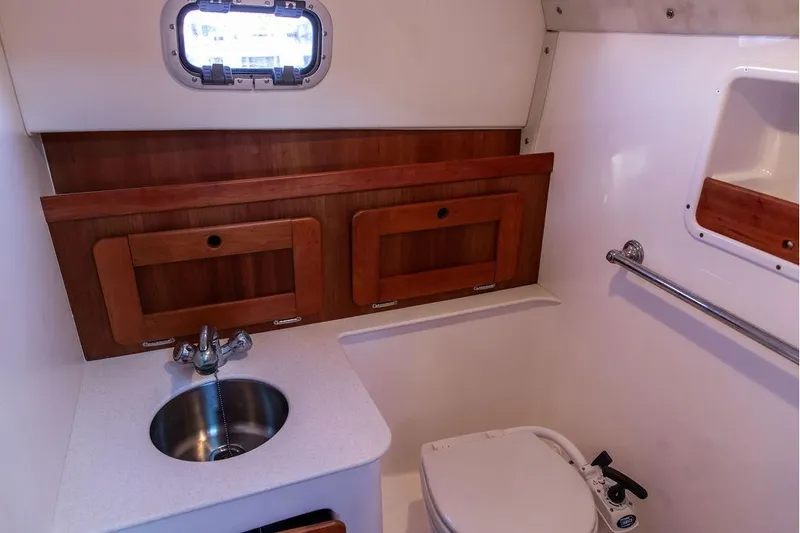 Slide: The Image of 2007 Hunt Surfhunter 29 boat bathroom with sink, toilet, and wooden cabinetry. - 46
