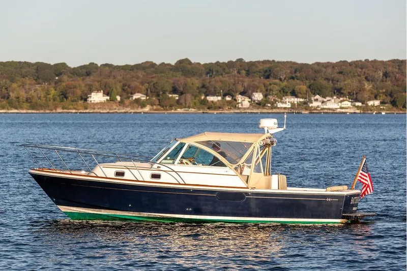 Slide: The Image of 2007 Hunt Surfhunter 29 boat on calm water with scenic shoreline background. - 5
