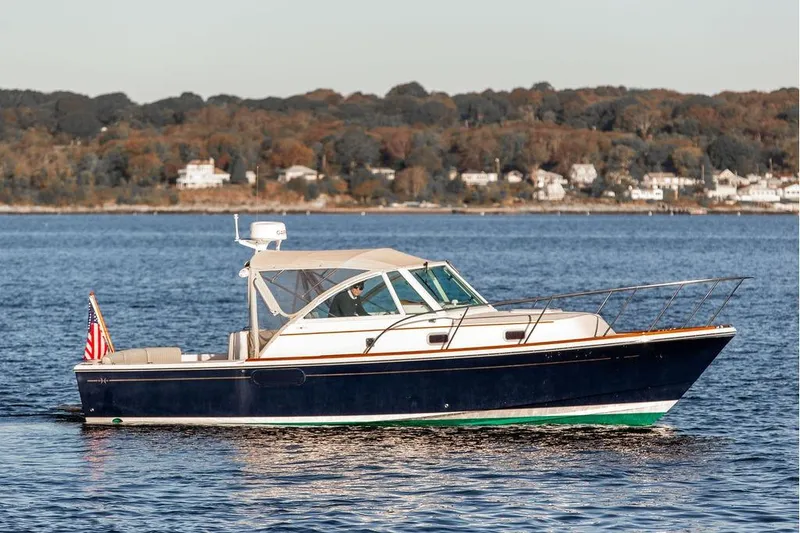 Slide: The Image of 2007 Hunt Surfhunter 29 boat cruising on a calm lake with scenic shoreline. - 12