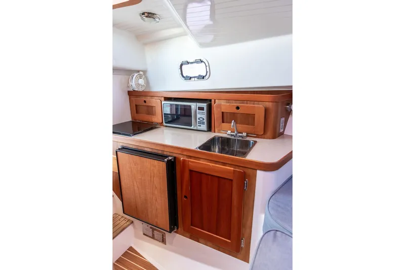 Slide: The Image of Compact kitchen in 2007 Hunt Surfhunter 29 boat with wood cabinetry and modern appliances. - 35
