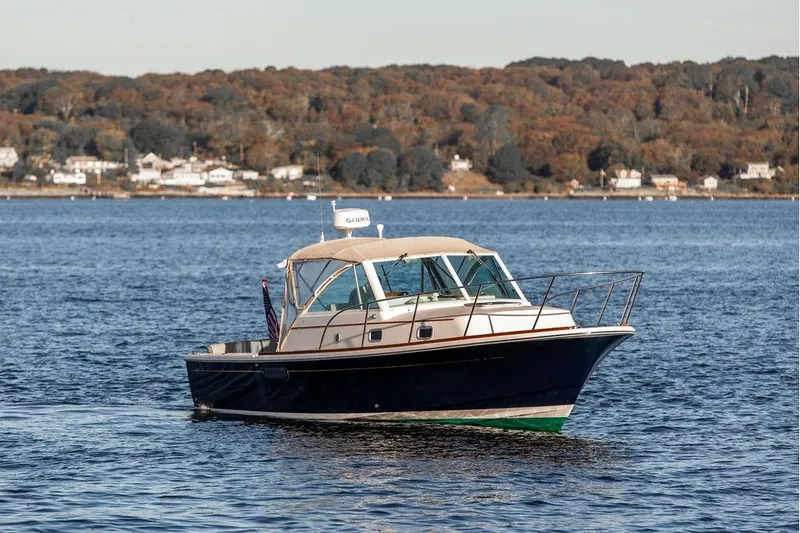 Slide: The Image of 2007 Hunt Surfhunter 29 boat on calm water with scenic shoreline background. - 4