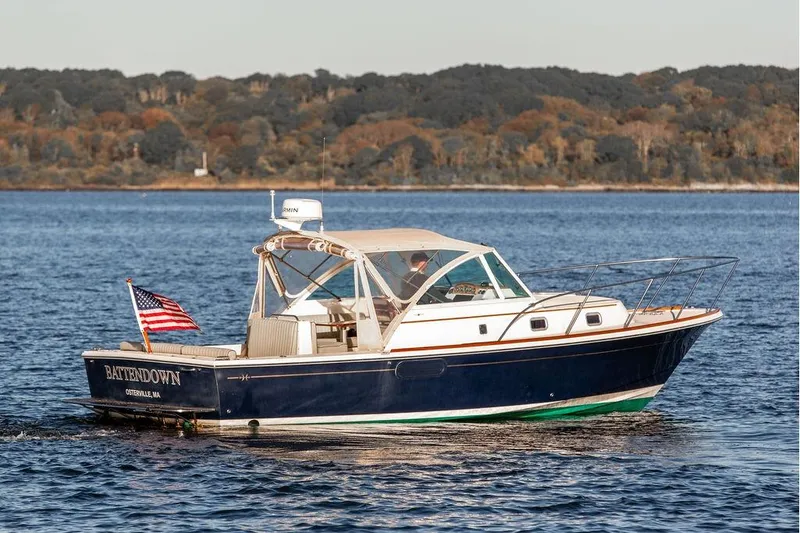 Slide: The Image of 2007 Hunt Surfhunter 29 boat cruising on a calm lake with forested shoreline. - 8