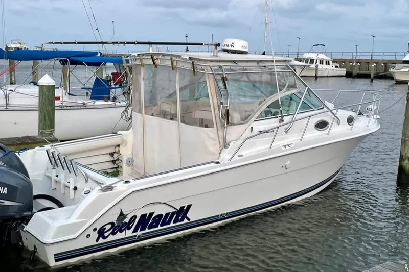 The Image of 2000 Wellcraft 290 Coastal boat docked in marina, featuring sleek design and Yamaha outboard motor. - 0