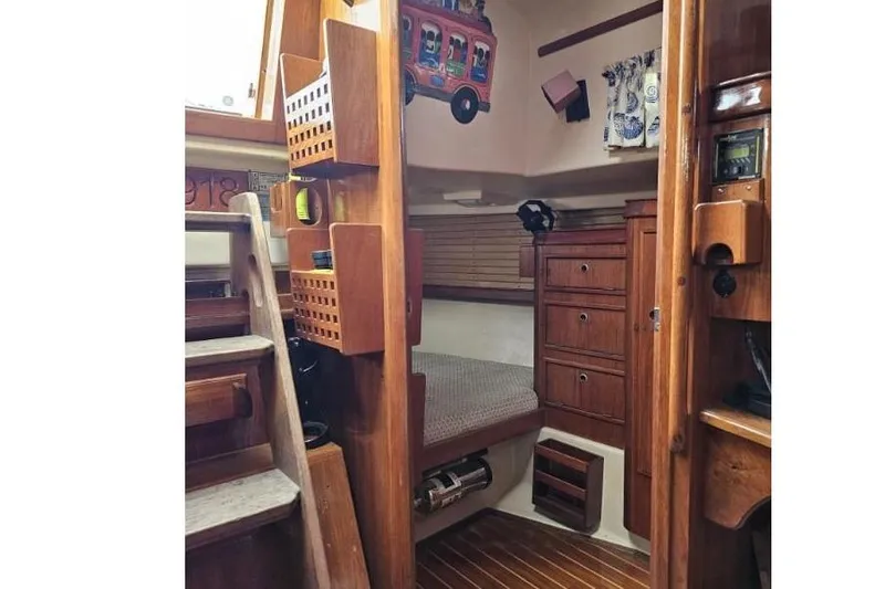 Slide: The Image of 1999 Island Packet 350 interior with wooden cabinetry, cozy seating, and nautical decor. - 15