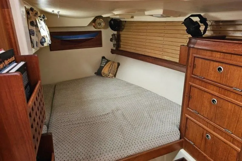 Slide: The Image of Cozy cabin interior of 1999 Island Packet 350 sailboat with wooden cabinetry and bedding. - 16