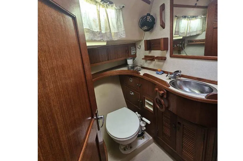Slide: The Image of 1999 Island Packet 350 yacht bathroom with wooden cabinetry and stainless steel sink. - 23