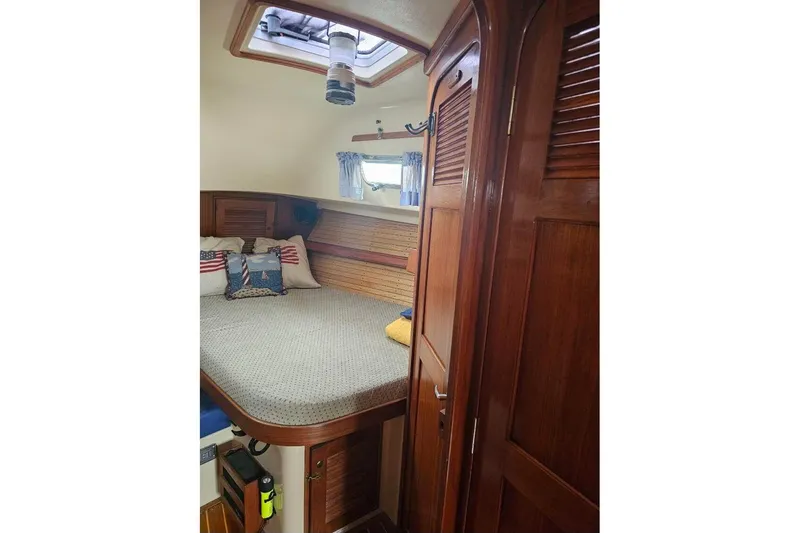 Slide: The Image of Cozy cabin interior of 1999 Island Packet 350 sailboat with wooden finishes and bedding. - 25