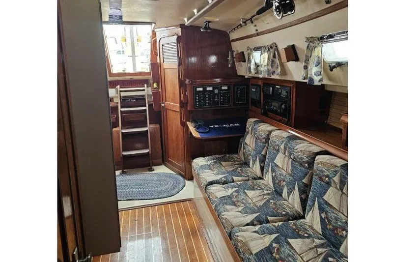 Slide: The Image of Interior of 1999 Island Packet 350 sailboat with nautical-themed upholstery and wooden finishes. - 5