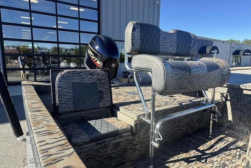 Slide: The Image of 2026 Xpress H20B Bay boat with camo seating and powerful outboard motor. - 7