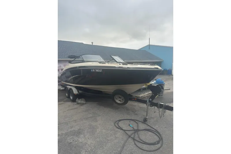 The Image of 2015 Yamaha Boats 242 Limited on trailer, parked outdoors. - 1