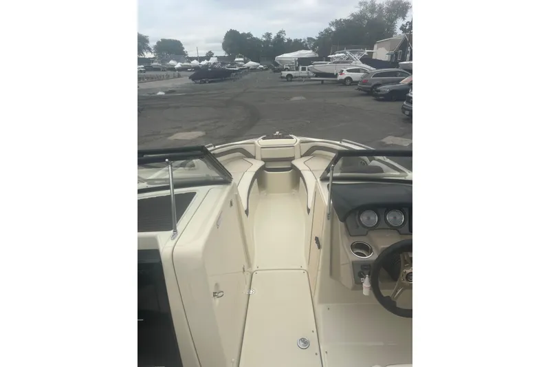 Slide: The Image of 2015 Yamaha Boats 242 Limited interior view at marina, showcasing dashboard and seating area. - 12