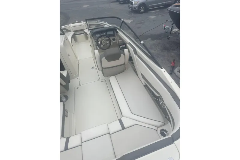 Slide: The Image of 2015 Yamaha Boats 242 Limited interior with steering wheel and seating, parked outdoors. - 13