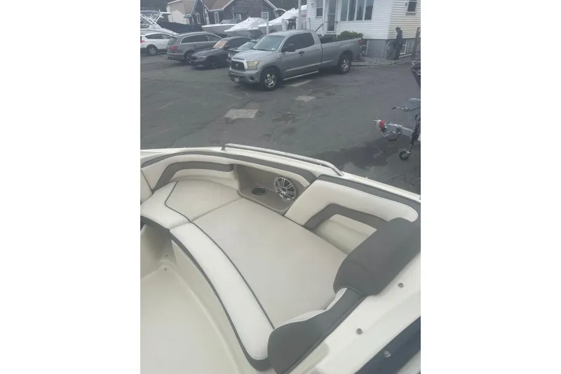 Slide: The Image of 2015 Yamaha Boats 242 Limited interior with beige seating, parked in a lot. - 21