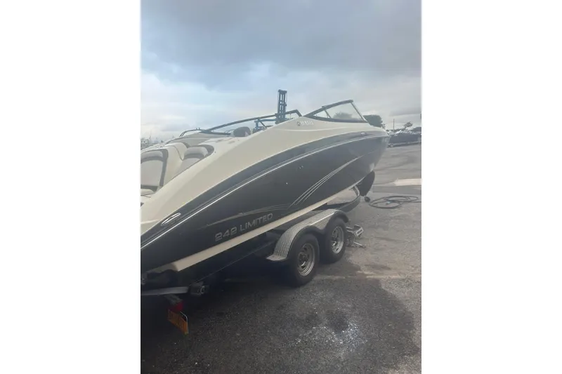 Slide: The Image of 2015 Yamaha Boats 242 Limited on trailer, parked outdoors under cloudy sky. - 3