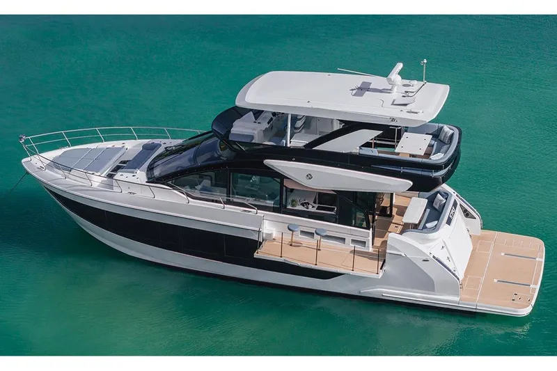 The Image of 2026 Cruisers Yachts 57 Fly cruising on calm waters under a clear blue sky. - 0