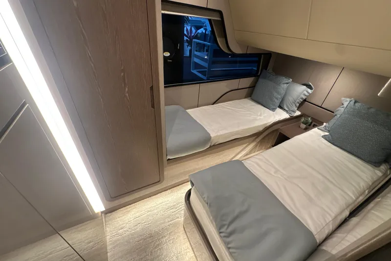 Slide: The Image of 2026 Cruisers Yachts 57 Fly cabin with twin beds and modern interior design. - 23