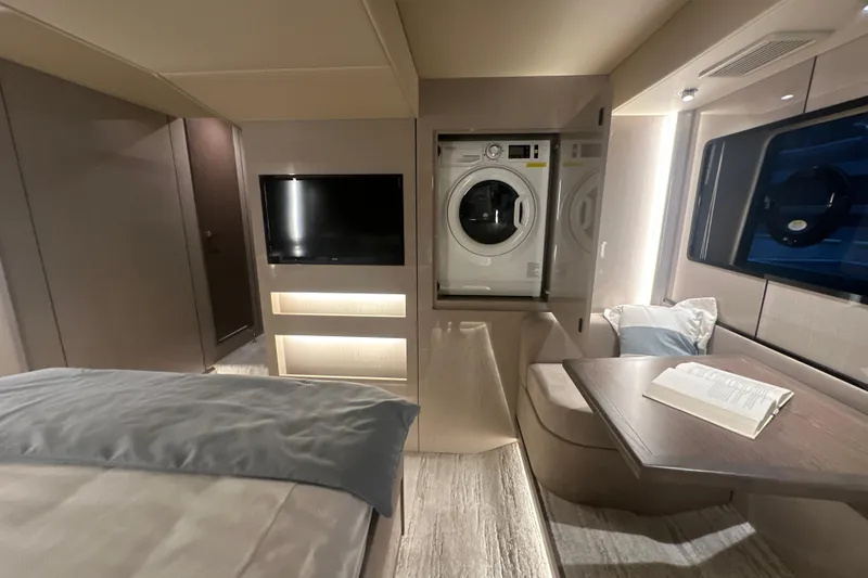 Slide: The Image of Luxurious 2026 Cruisers Yachts 57 Fly interior with washer, TV, and cozy seating area. - 40
