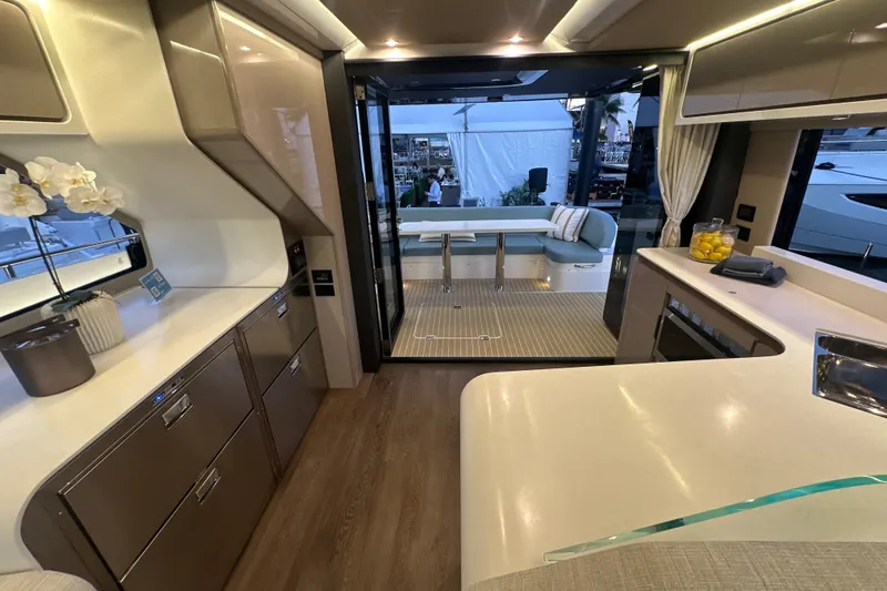 Slide: The Image of Luxurious interior of 2026 Cruisers Yachts 57 Fly, featuring modern kitchen and elegant seating area. - 47
