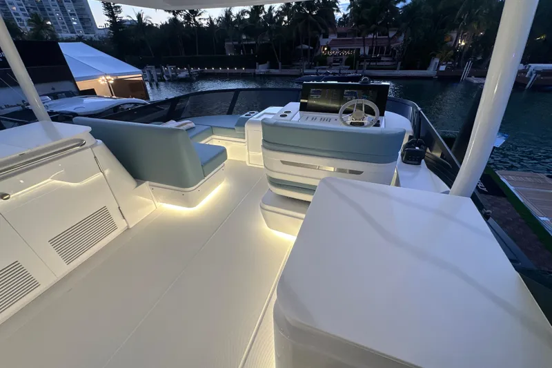 Slide: The Image of 2026 Cruisers Yachts 57 Flybridge with illuminated seating and helm at dusk. - 50