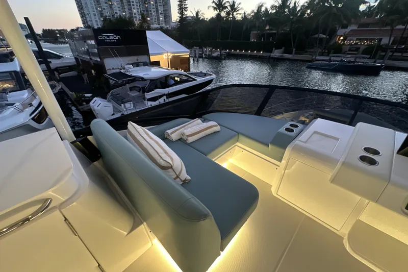 Slide: The Image of Luxurious seating area on 2026 Cruisers Yachts 57 Fly, illuminated at dusk by the water. - 56