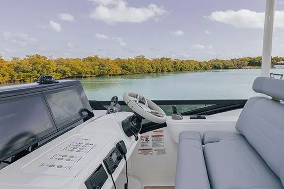 Slide: The Image of Manufacturer Provided Image: 2026 Cruisers Yachts 57 Fly helm with scenic water view and lush greenery. - 4