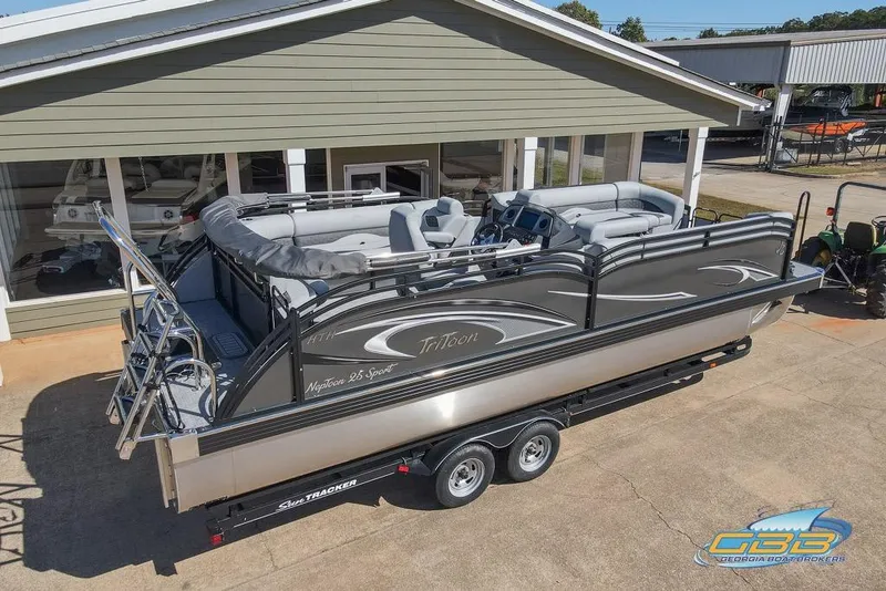 Slide: The Image of 2026 JC 25 Neptoon LG pontoon boat on trailer, parked outside showroom. - 14