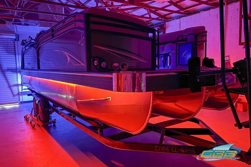 Slide: The Image of 2026 JC 25 Neptoon LG pontoon boat in vibrant red and blue lighting. - 4