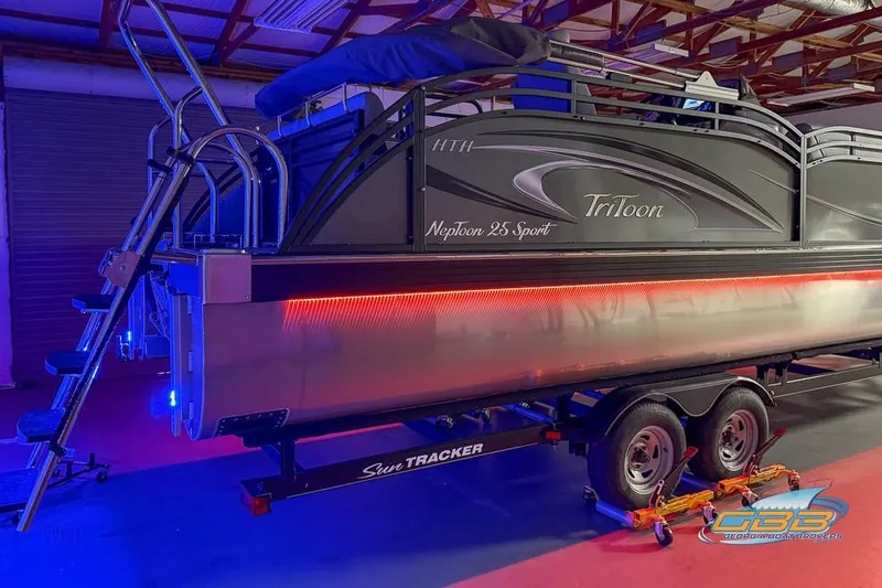 Slide: The Image of 2026 JC 25 Neptoon LG pontoon boat with vibrant LED lighting on trailer. - 59