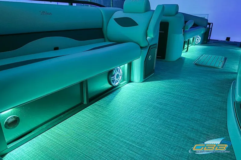 Slide: The Image of 2026 JC 25 Neptoon LG boat interior with ambient teal lighting and modern seating. - 61