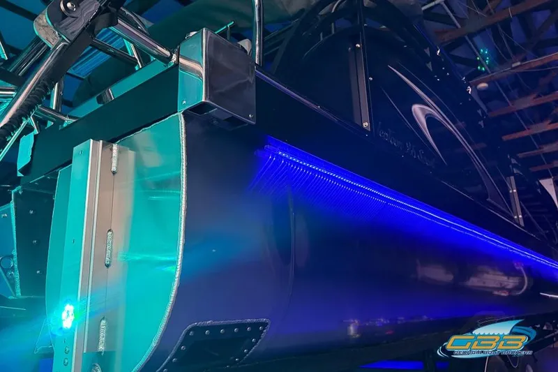 Slide: The Image of 2026 JC 25 Neptoon LG pontoon boat with blue LED lighting in a garage. - 64