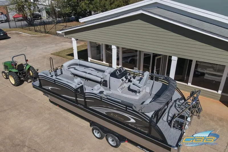 Slide: The Image of 2026 JC 25 Neptoon LG pontoon boat on trailer, parked near building. - 8