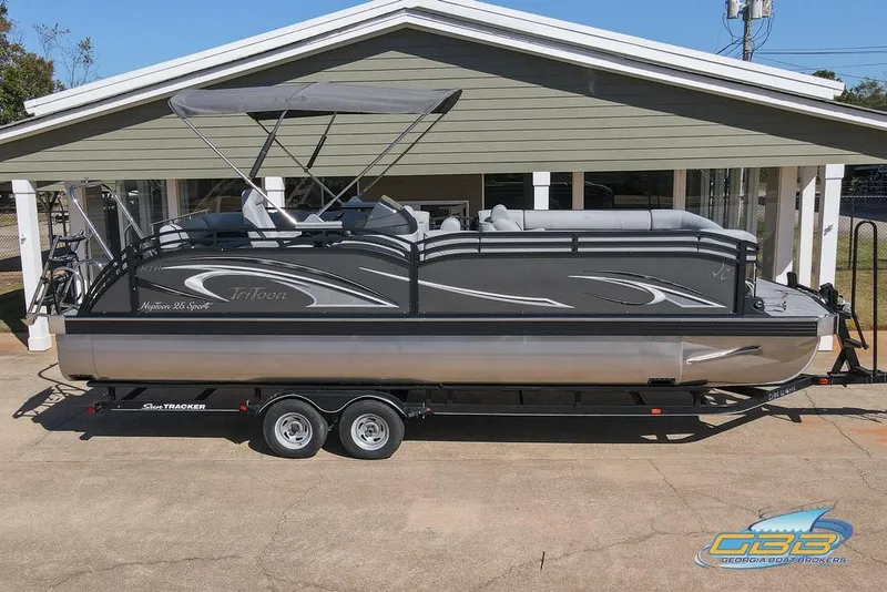 The Image of 2026 JC 25 Neptoon LG pontoon boat on trailer, parked outside a building. - 0