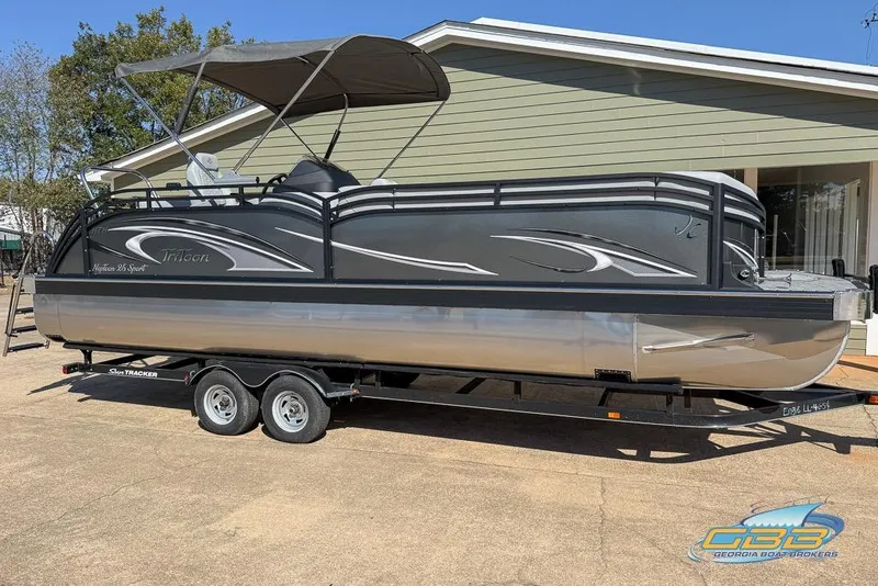 Slide: The Image of 2026 JC 25 Neptoon LG pontoon boat on trailer, parked outside a building. - 41