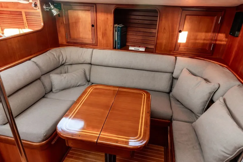Slide: The Image of Cozy interior of 1994 Hinckley Sou'wester 42 sailboat with wooden table and cushioned seating. - 16