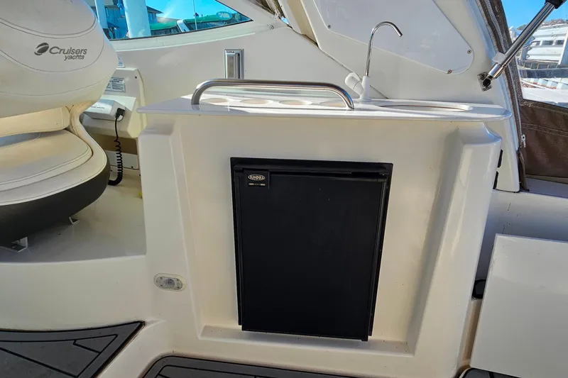 Slide: The Image of 2006 Cruisers Yachts 300 Express interior seating with white upholstery and waterfront view. - 11