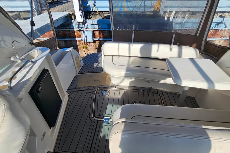 Slide: The Image of 2006 Cruisers Yachts 300 Express interior with helm, seating, and marina view. - 16