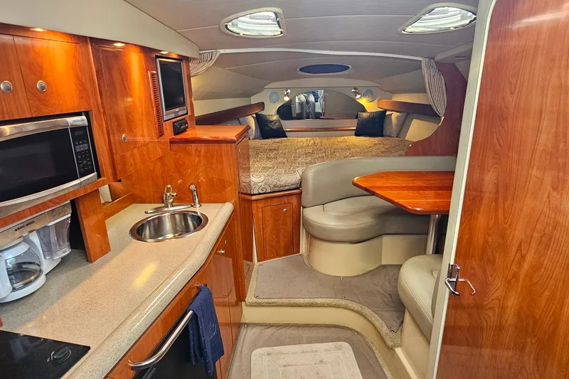 Slide: The Image of 2006 Cruisers Yachts 300 Express cabin interior with dining area and bed. - 19