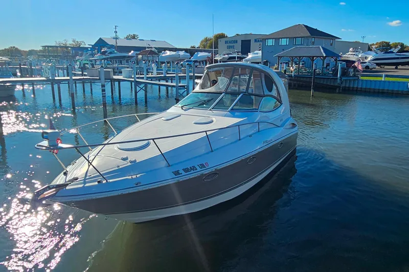 Slide: The Image of 2006 Cruisers Yachts 300 Express docked at marina under clear blue sky. - 5