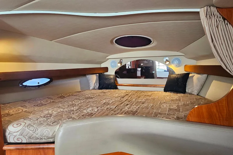 Slide: The Image of 2006 Cruisers Yachts 300 Express cabin interior with cozy bed and wooden furnishings. - 21