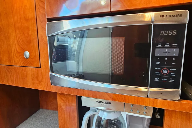 Slide: The Image of 2006 Cruisers Yachts 300 Express stovetop on speckled countertop. - 25