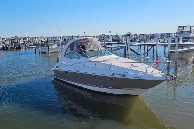 Slide: The Image of 2006 Cruisers Yachts 300 Express docked in a marina under clear blue skies. - 3