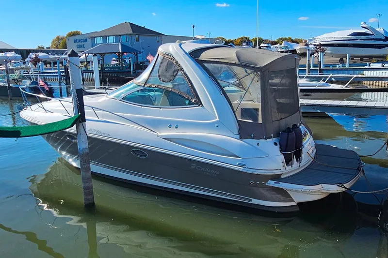 Slide: The Image of 2006 Cruisers Yachts 300 Express in marina, calm waters, clear sky. - 34