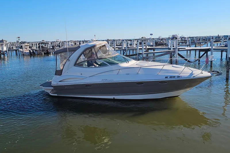 Slide: The Image of 2006 Cruisers Yachts 300 Express in marina, calm waters, clear sky. - 35