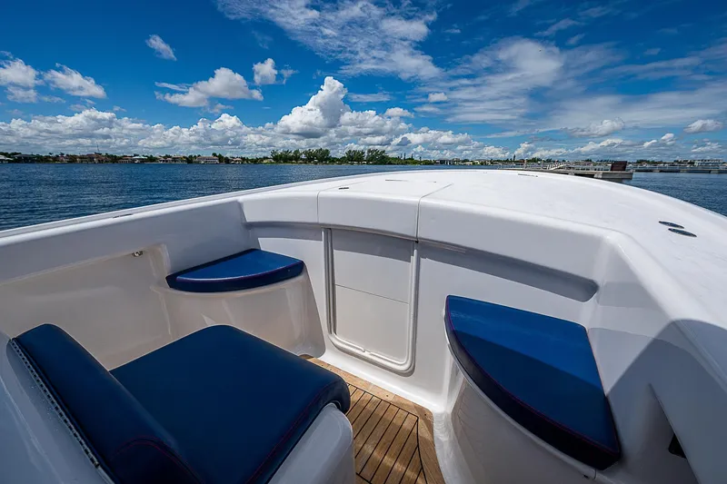 Slide: The Image of 2011 Winter Custom Yachts 29 boat interior with blue seating, under a clear blue sky. - 11